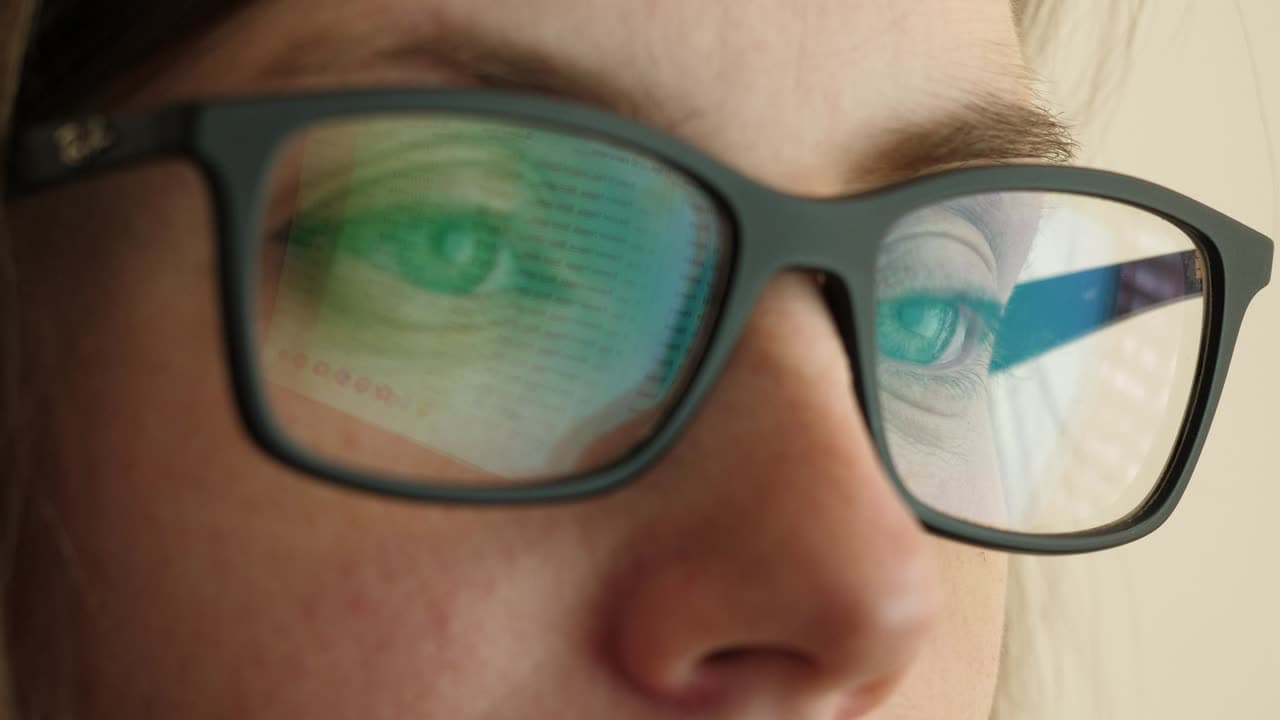 A computer screen reflected in a person's glasses