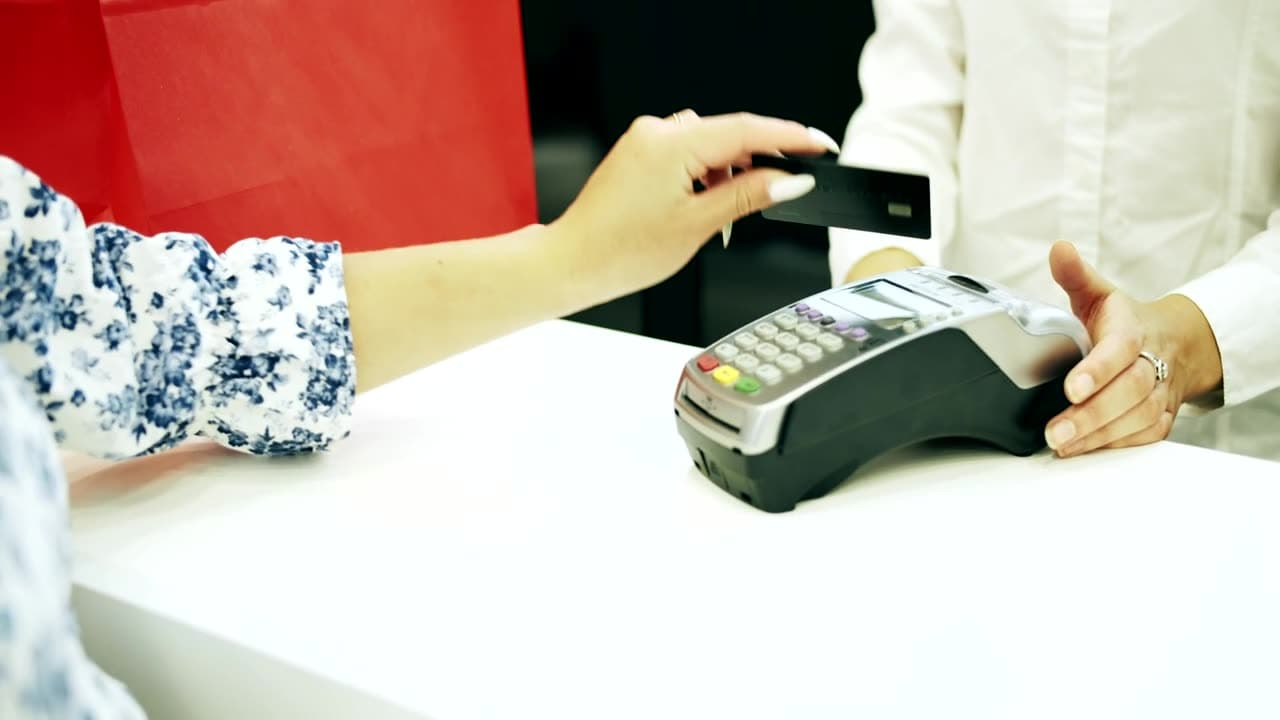 A customer paying by card at a shop counter